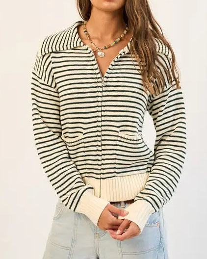 Woman wearing a black and white striped sweater on a plain background